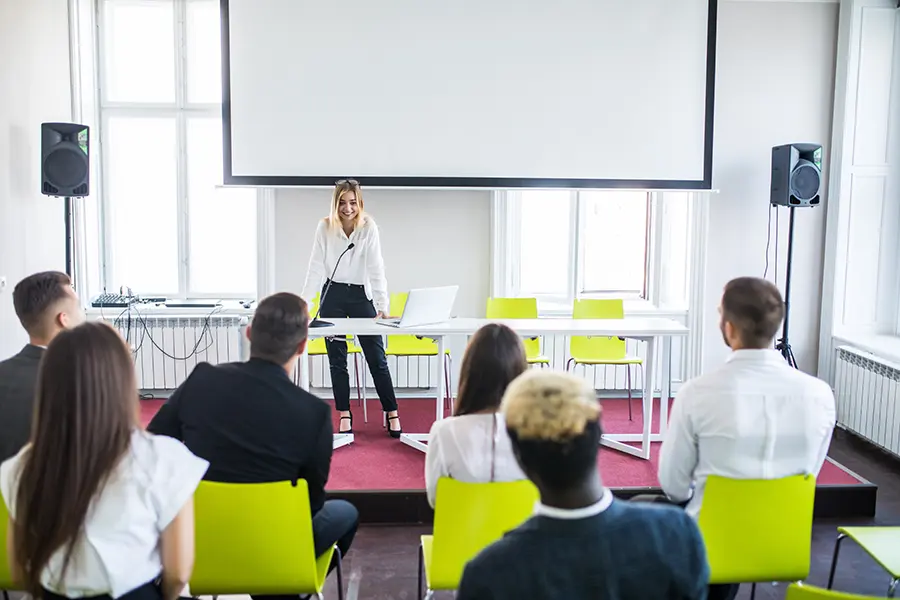 Female student presenting to classmates with AI-powered tools like hiCreo in a school setting