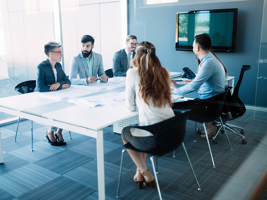 Startup team discussing pitch deck design strategies during an investor presentation meeting in a modern office setting.